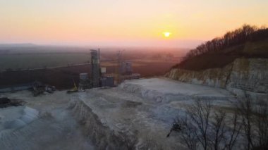 Çimento fabrikası inşaat için kum taşı malzemelerinin açık madenciliğinde. Gün batımında taş ocağında çakıl ocağı kazmak.