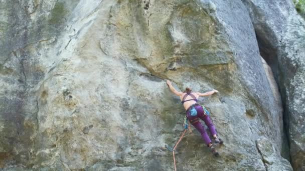 Mujer joven escalador cayendo después de attemp fallido para subir empinada pared de montaña rocosa. Participar en el concepto de deporte extremo — Vídeo de stock