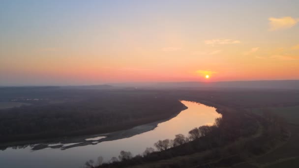 Luftaufnahme eines breiten Flusses, der ruhig im ländlichen Raum fließt, am Herbstabend — Stockvideo