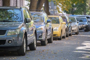 Sokak kenarında park halinde bir sürü araba olan şehir trafiği.