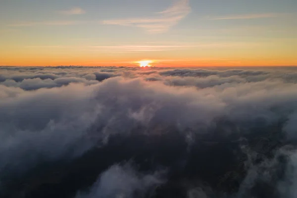 Vista aérea desde la ventana del avión a gran altitud de densas nubes de cúmulos hinchados volando por la noche —  Fotos de Stock