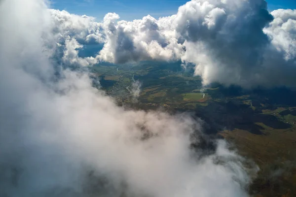 Vista aérea desde la ventana del avión a gran altitud de la tierra cubierta de nubes de cúmulos hinchados que se forman antes de la tormenta —  Fotos de Stock