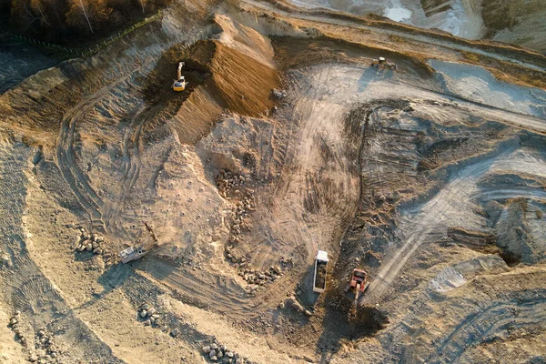 Vista aérea do local de mineração a céu aberto de materiais de pedra calcária para a indústria da construção com escavadeiras e caminhões basculantes — Fotografia de Stock