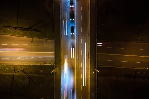 Luftaufnahme einer Straßenkreuzung mit starkem Verkehr in der Nacht. Blick von oben auf den städtischen Verkehr. Rush Hour mit Bewegungsunschärfe von Autofahrerampeln — Stockfoto