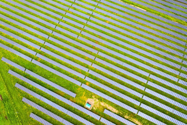 Vista aérea de la planta de energía solar en campo verde. Paneles eléctricos para producir energía ecológica limpia — Foto de Stock