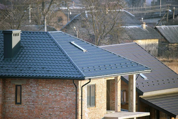 Casa in mattoni con tetto coperto con tegole metalliche. Copertura in maiolica di edifici in costruzione — Foto Stock