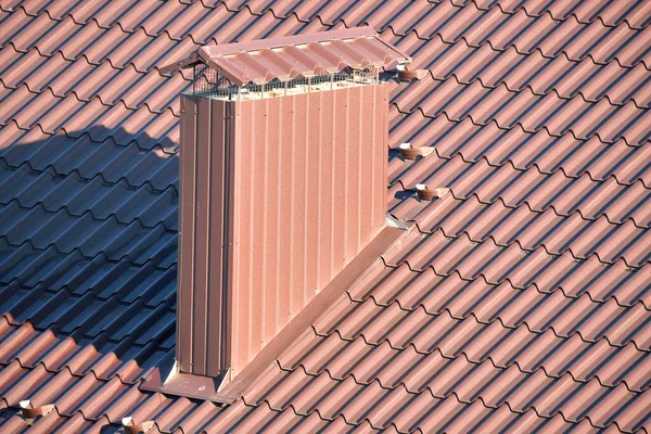 Chimney on house roof top covered with metallic shingles under construction. Tiled covering of building. Real estate development — Stock Photo, Image