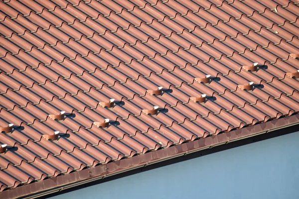 Detailní sněhová ochranka pro bezpečnost v zimě na střeše domu pokryté ocelovými pásovými opasky. Dlážděná krytina budovy — Stock fotografie