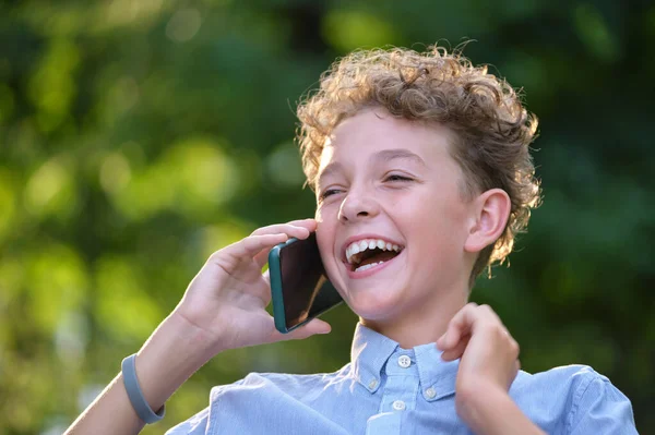 Feliz joven adolescente hablando por teléfono móvil al aire libre en el parque de verano. concepto de amistad en línea —  Fotos de Stock