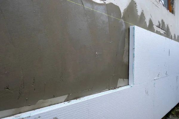 Instalación de láminas de aislamiento de espuma de poliestireno en la pared de la fachada de la casa para protección térmica —  Fotos de Stock