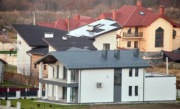 Domy mieszkalne z dachami pokrytymi gontami metalowymi i ceramicznymi na obszarach wiejskich podmiejskich — Zdjęcie stockowe
