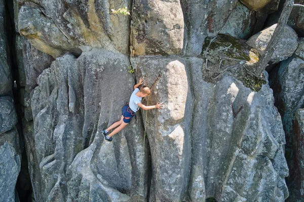 Strong child climber climbing steep wall of rocky mountain. Young boy overcoming difficult route. Engaging in extreme sports hobby concept — Stock Photo, Image