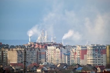 Yüksek fabrika yapısına sahip çimento fabrikası ve şehir merkezi yakınlarındaki endüstriyel üretim alanındaki vinçler. Üretim ve küresel sanayi kavramı
