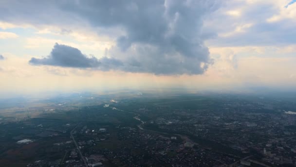 Vzdušný pohled z okna letadla ve vysoké nadmořské výšce vzdáleného města pokrytého nadýchanými kumulativními mraky, které se formovaly před deštěm — Stock video