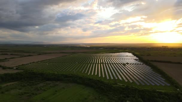 Vista aérea de uma grande usina elétrica sustentável com fileiras de painéis solares fotovoltaicos para produzir energia elétrica ecológica limpa ao pôr do sol. Eletricidade renovável com conceito de emissão zero — Vídeo de Stock