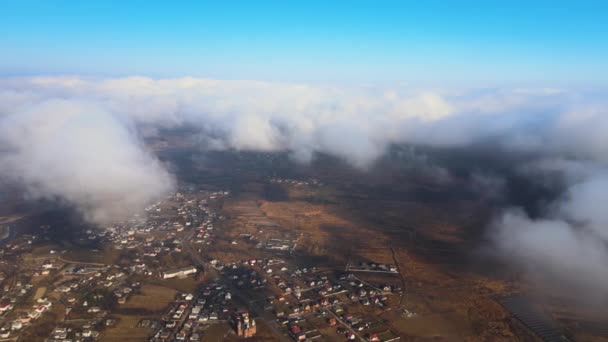 暴風雨の前に形成されたパフィー積雲に覆われた遠くの都市の高高度からの空中ビュー。曇りの風景の航空機の視点 — ストック動画