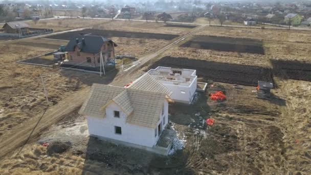 Havalandırılmış hafif beton duvarları ve yapım aşamasındaki ahşap çatı iskeleti olan bitmemiş özel evin havadan görüntüsü. — Stok video