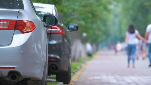 Tráfico urbano con coches estacionados en línea en el lado de la calle — Vídeo de stock