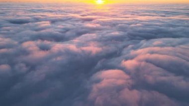 Yükseklerden gökyüzü manzarası. Akşamları yoğun, kabarık kümülüs bulutları uçuşuyor. Uçak penceresinden gün batımı inanılmaz.