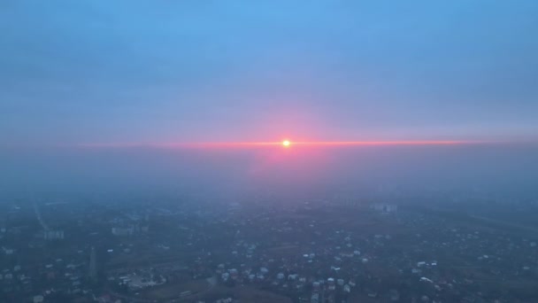 Letecký pohled z okna letadla ve vysoké výšce země pokrytý bílou tenkou vrstvou mlhavého oparu a vzdálených mraků při západu slunce — Stock video