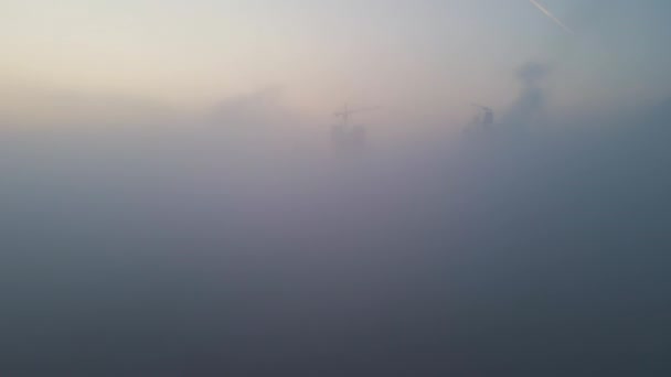 雾天早晨，工业园区内具有高混凝土厂房结构和塔式起重机的水泥厂的空中景观。制造业和全球工业概念 — 图库视频影像