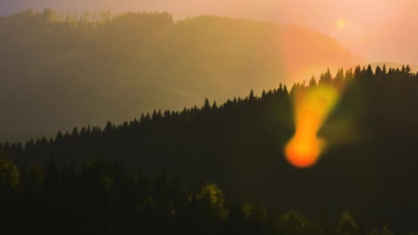夕暮れ時に遠くの山の峰の上に明るい夕日と美しい夜のパノラマ風景 — ストック動画