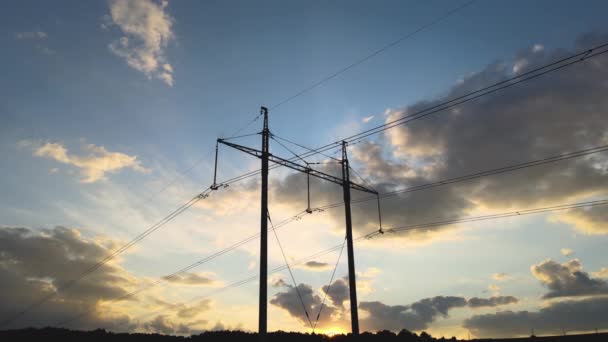 해질 녘에 전력선 이 있는 고압 탑의 어두운 실루엣. 전기의 수송 개념 — 비디오