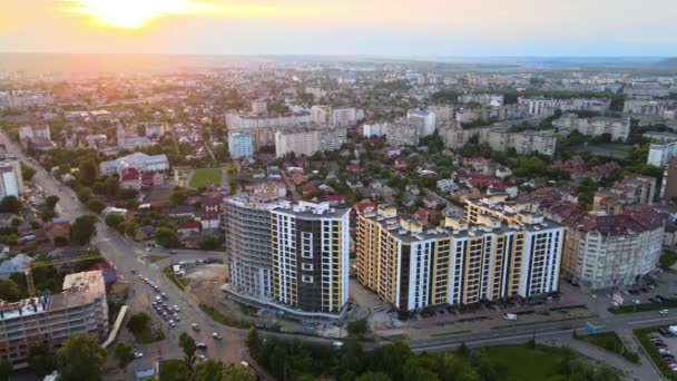 Uitzicht vanuit de lucht op hoogbouw appartementengebouwen, privéhuizen en straten in de woonwijk van de stad 's avonds — Stockvideo