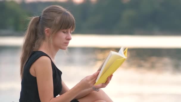 Wanita muda yang beristirahat di taman musim panas membaca buku. Pendidikan dan konsep sudy — Stok Video