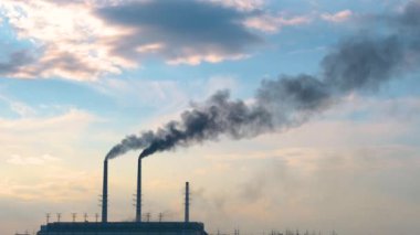 Termik santrale yakın siyah dumanlı yüksek borular atmosferi kirletiyor. Fosil yakıt kavramına sahip elektrik enerjisi üretimi