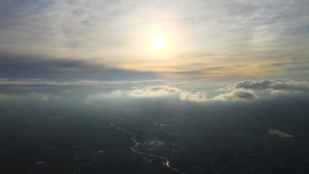 Légi kilátás a nagy magasságban a távoli város borított puffadt felhők képződnek vihar előtt este. Repülőgép szempontjából felhős táj — Stock videók