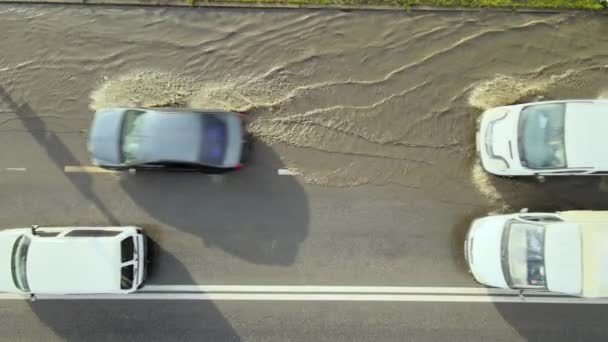 Vista aérea del tráfico de la ciudad con los coches que conducen en la calle inundada después de fuertes lluvias. Problemas con el sistema de drenaje de carreteras — Vídeo de stock