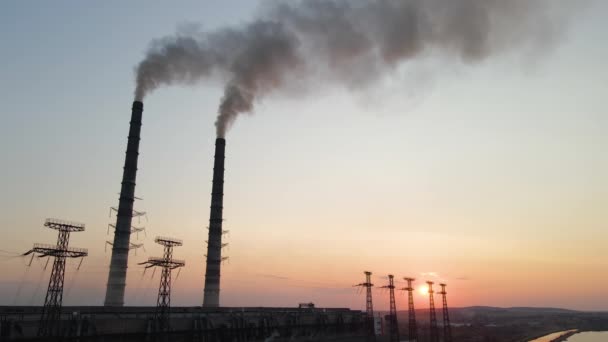 Luchtfoto van hoge pijpen van kolencentrales met zwarte rook die bij zonsondergang naar boven beweegt en vervuilende atmosfeer. Productie van elektrische energie met fossiele brandstoffen — Stockvideo