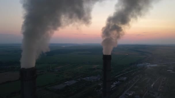 Légi felvétel szénerőmű magas csövek fekete füst mozog felfelé szennyező légkör naplementekor. Villamosenergia-termelés fosszilis tüzelőanyaggal — Stock videók