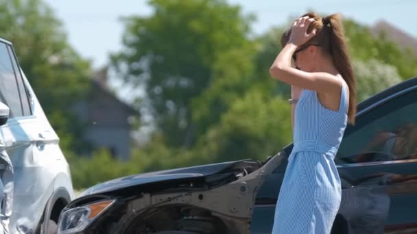 Droevige vrouwelijke bestuurder die spreekt op de sellphone aan de straatkant die belt voor de hulpdiensten na een auto-ongeluk. Verkeersveiligheid en verzekeringsconcept — Stockvideo