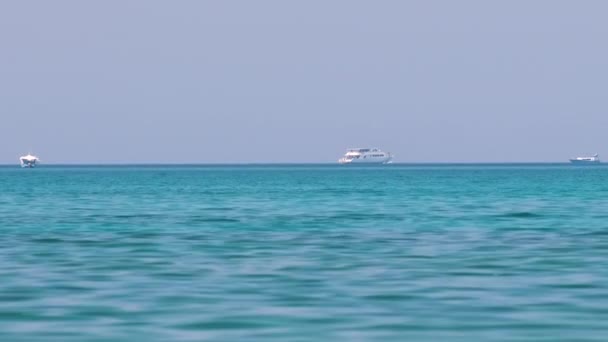 Seelandschaft mit welliger Oberfläche aus blauem Meerwasser mit weit entfernten Schiffen, die auf ruhigen Wellen schwimmen — Stockvideo
