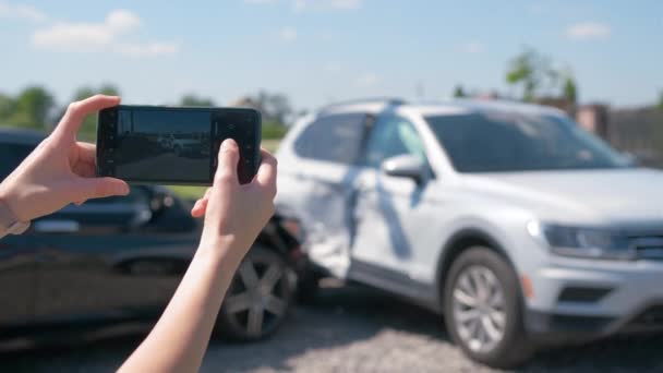 Gestresste bestuurder neemt foto op sellphone camera van vernield voertuig bellen voor de hulpdiensten hulp na auto-ongeluk. Verkeersveiligheid en verzekeringsconcept — Stockvideo