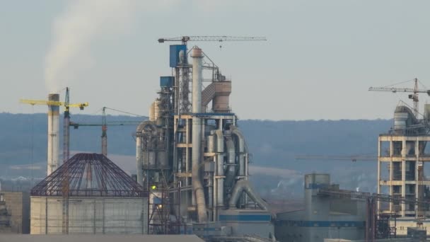 Timelapse de cimenterie avec structure d'usine élevée et grues à tour dans la zone de production industrielle. Fabrication et concept d'industrie mondiale — Video