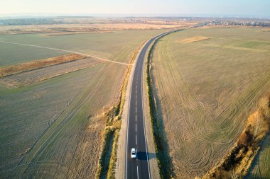 Gün batımında hızlı giden bulanık arabalı şehirlerarası yol manzarası. Akşamları otoban trafiğinin insansız hava aracı görüntüsü