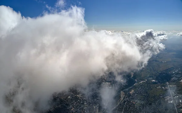 Luftaufnahme aus dem Flugzeugfenster in großer Höhe der Erde, bedeckt mit geschwollenen Kumuluswolken, die sich vor dem Regensturm bilden — Stockfoto