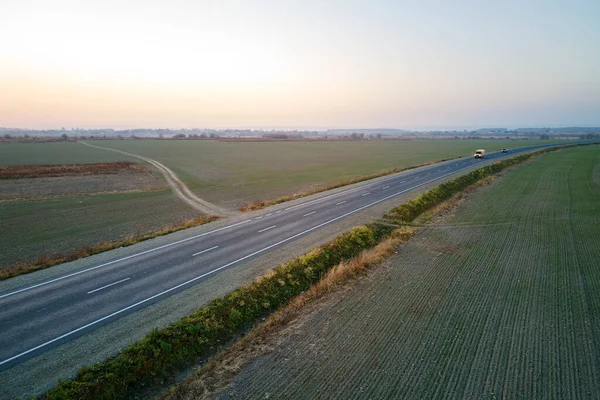 Вид с воздуха на пустую междугороднюю дорогу на закате. Вид сверху с дрона шоссе в вечернее время — стоковое фото