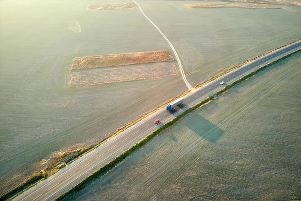 Вид с воздуха на междугороднюю дорогу с быстрыми автомобилями на закате. Вид сверху с дрона дорожного движения в вечернее время — стоковое фото