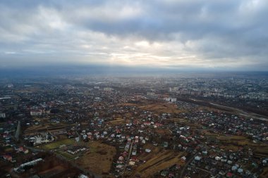 Bulutlu havalarda kırsal evlerin ve şehrin yerleşim alanındaki yüksek katlı apartmanların havadan görünüşü