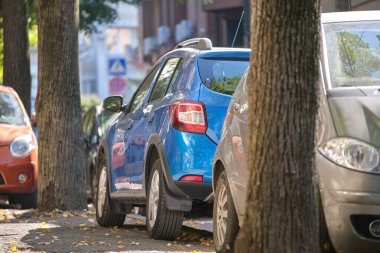 Sokak kenarında park halinde bir sürü araba olan şehir trafiği.