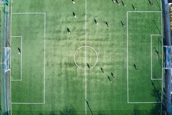 Vista aérea de jogadores de futebol que jogam futebol no estádio de esportes verdes — Fotografia de Stock