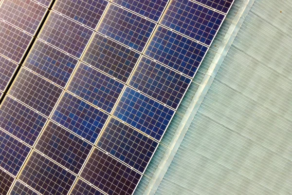 Primo piano della superficie dei pannelli solari fotovoltaici blu montati sul tetto dell'edificio per produrre energia elettrica ecologica pulita. Concetto di produzione di energie rinnovabili — Foto Stock