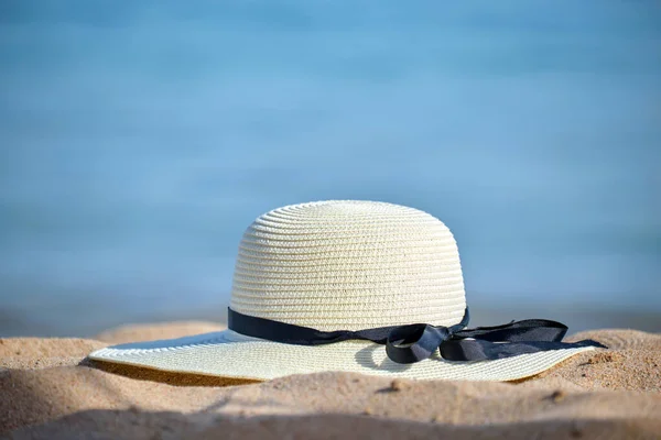 Primer plano del sombrero de paja amarillo en la playa de arena en la costa tropical en un día cálido y soleado. Concepto vacaciones de verano —  Fotos de Stock