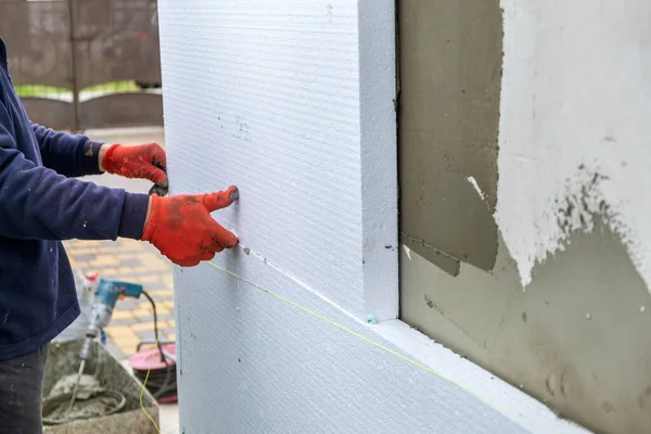 Trabajador de construcción instalando láminas de aislamiento de espuma de poliestireno en la pared de la fachada de la casa para protección térmica —  Fotos de Stock