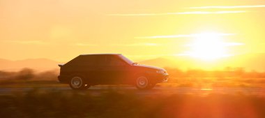 Gün batımında şehir içi yolda hızlı giden bir araba. Akşamları otoyol trafiği