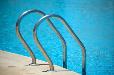 Yüzme havuzuna yakın paslanmaz çelik korkuluklar kaplumbağaların temiz havuz suyuna iniyor. Eğlence etkinlikleri kavramının erişilebilirliği